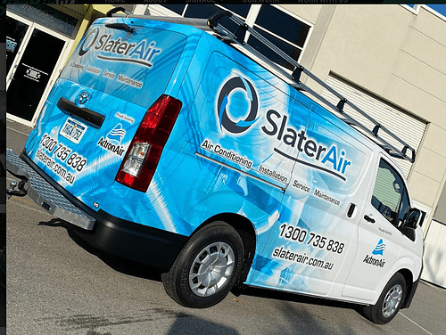 Blue SlaterAir service van with large logo, phone number and website graphics parked outside a commercial building.