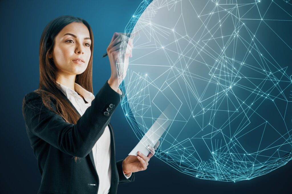 Businesswoman in a suit holding a tablet and stylus interacting with a glowing wireframe network globe