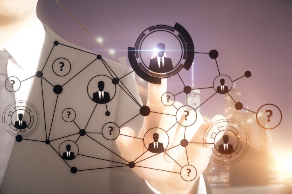 Businessperson in suit touching a digital network of connected silhouetted avatar icons and question-mark nodes.