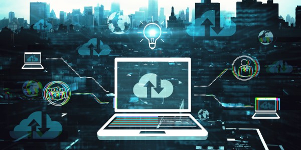 Laptop displaying cloud sync icon, surrounded by network and cloud symbols over a city skyline.