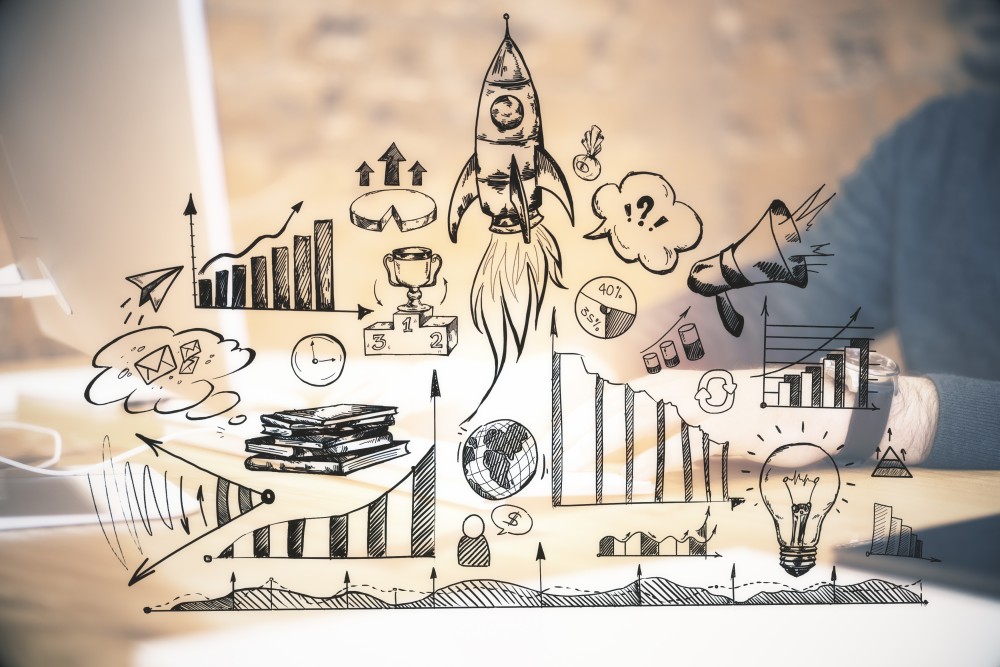 Hand-drawn business doodles—rocket, bar and line charts, lightbulb, trophy and books—over a blurred laptop workspace