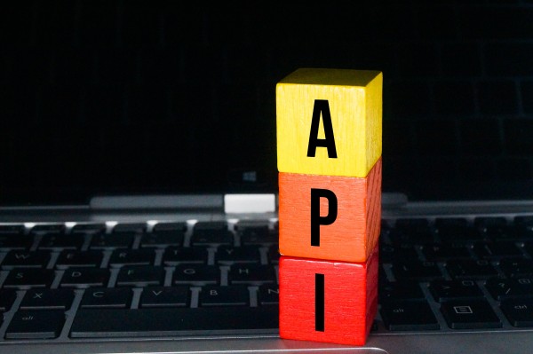 Three stacked coloured wooden blocks labelled A, P, I on a laptop keyboard.